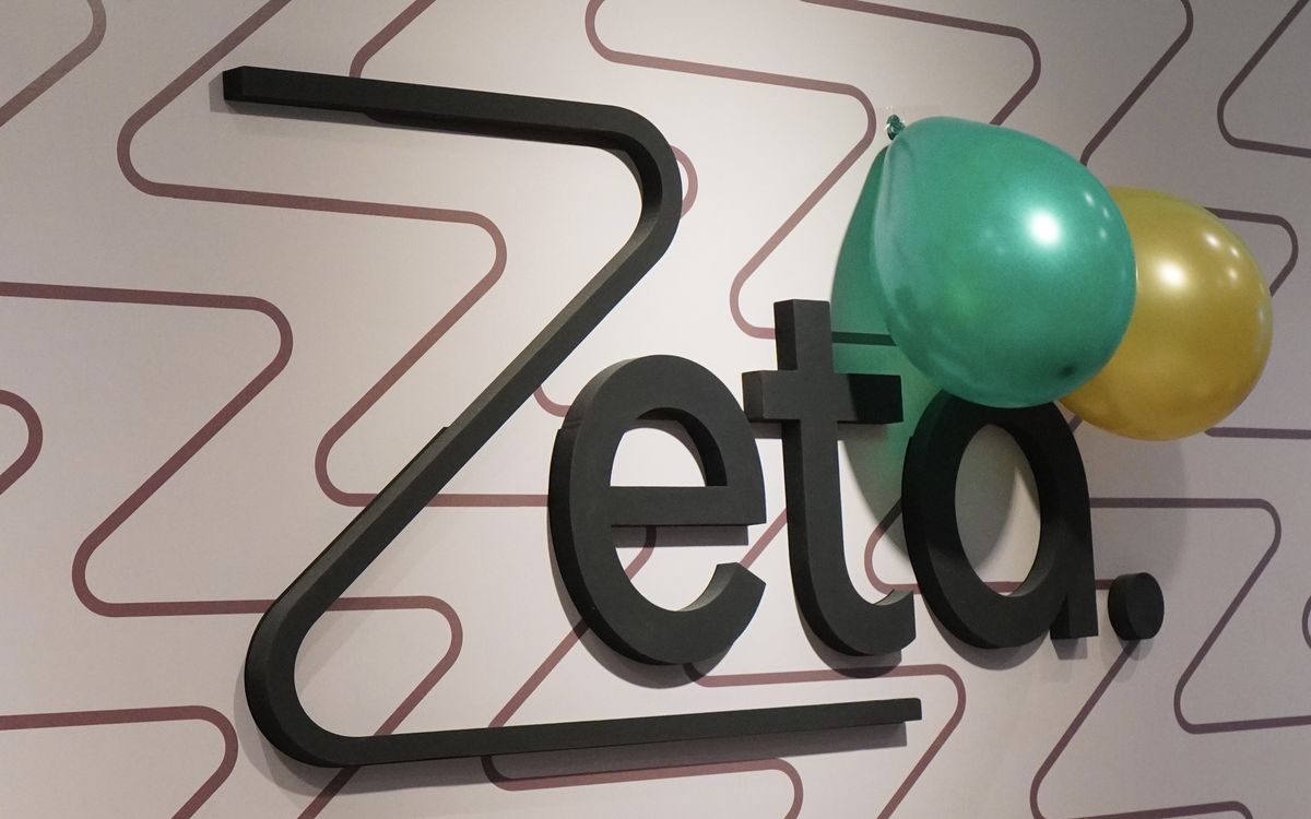Logo de Zeta en la pared del local, decorado con globos por el aniversario